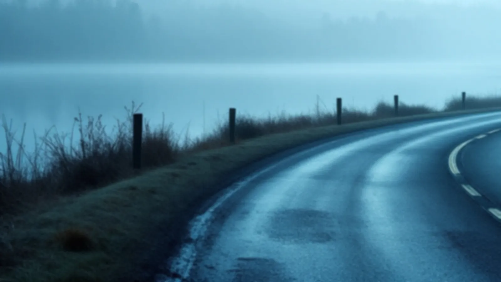 An empty road curving gently along a calm lake shore at dawn, the AxleYield view of short-term loans online, $100 – $5,000